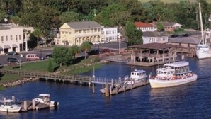 A historic St. Marys waterfront with buildings, a dock, and a boat. - Microtel Inn & Suites by Wyndham Kingsland Naval Base I-95 (Kingsland)