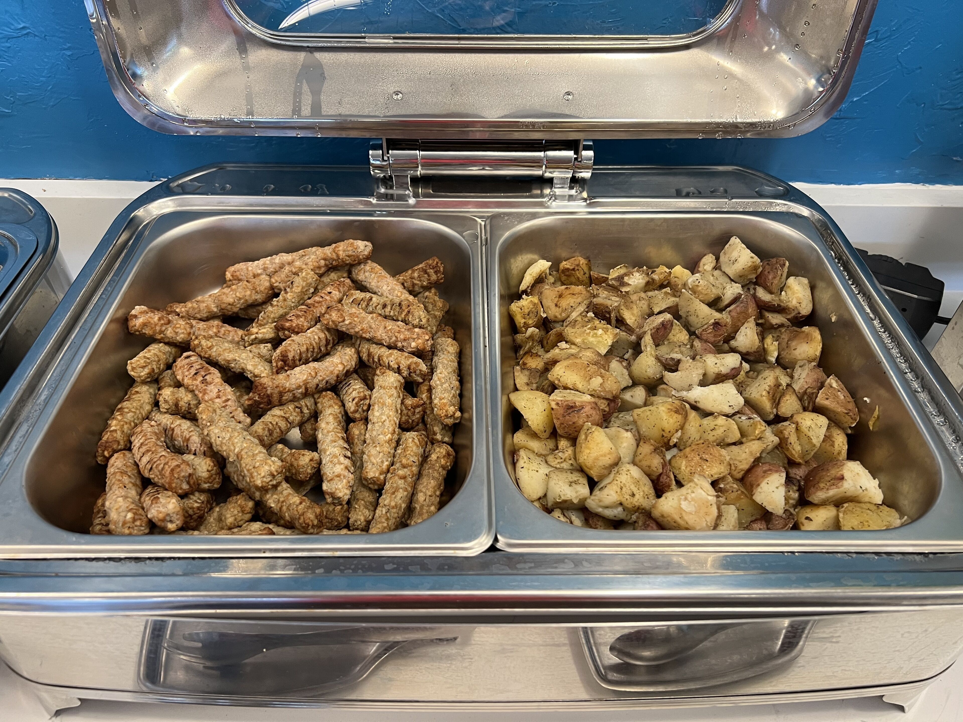 Un buffet avec deux plateaux en métal contenant des aliments.