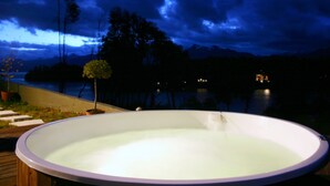 A hot tub with a view of a lake and mountains at night. - Las Ramblas de Puerto Manzano (Villa La Angostura)