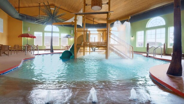 An indoor swimming pool with a slide, a water fountain, and a wooden play structure. - Country Inn & Suites by Radisson, Appleton North, WI (Little Chute)