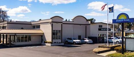 A Days Inn hotel with a parking lot, a covered waiting area, and a signboard.