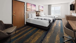 A hotel room with two beds, a desk, a chair, a TV, and artwork on the walls. - La Quinta Inn & Suites by Wyndham Kennewick (Kennewick)