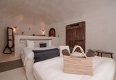 A bedroom with two beds, a wooden headboard, a woven basket, and a small table with a book.