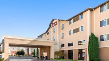 Experience the sleek design of this Hampton Inn, featuring a flat roof and grid-patterned windows.