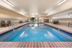 Una piscina techada, sillones reclinables de piscina