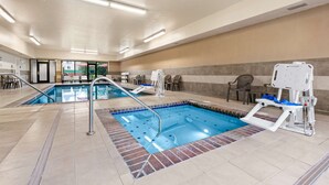 An indoor swimming pool with a clear view of the pool area, including the poolside chairs and a lifeguard stand.