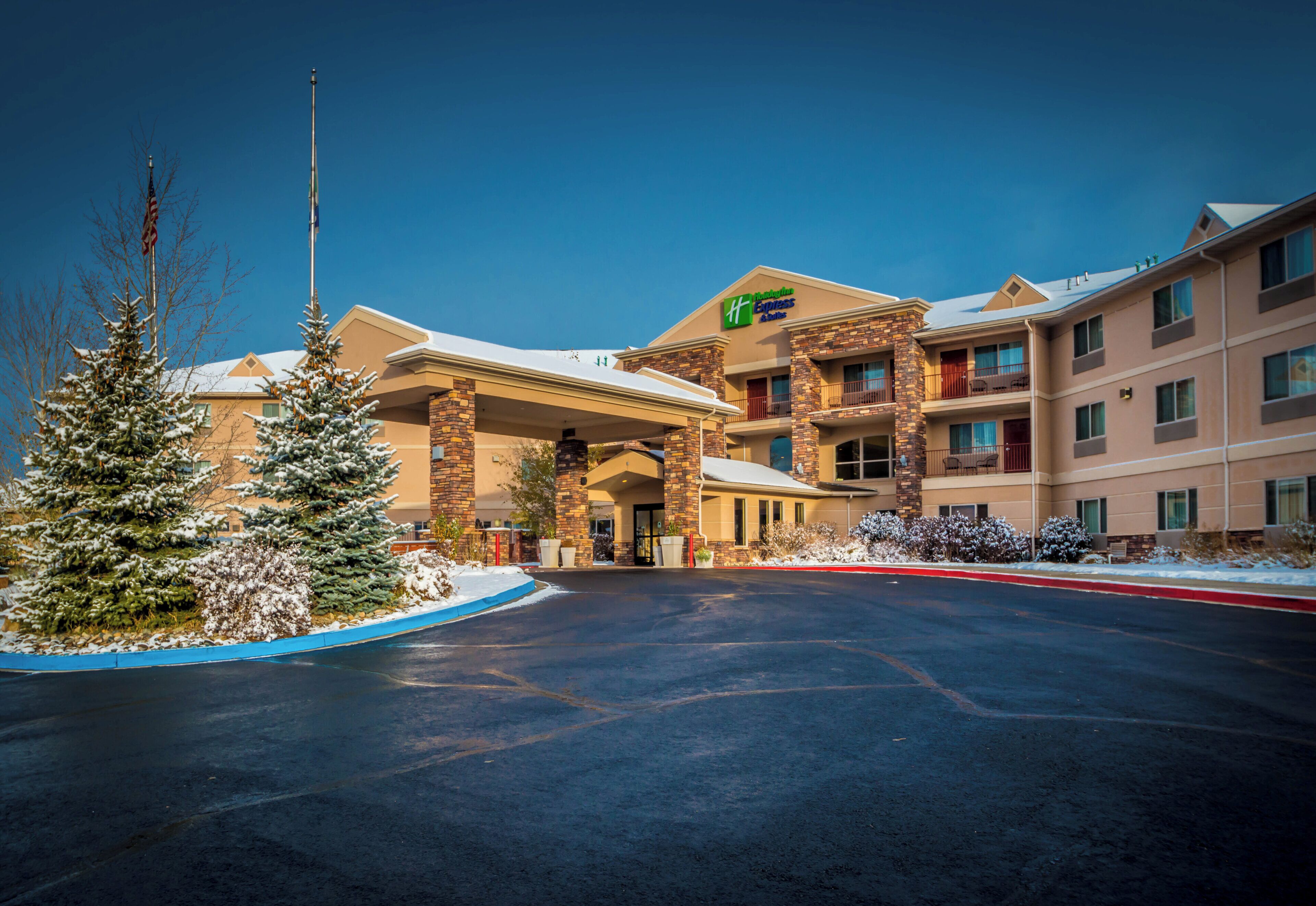 A hotel with a covered entrance, multiple floors, and a snow-covered landscape.
