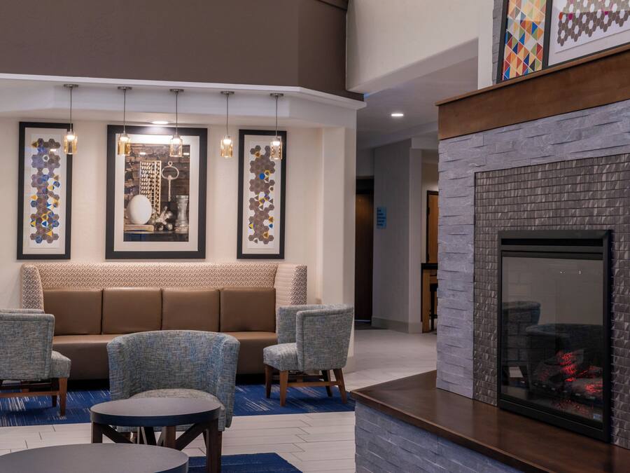 A modern lounge area with a fireplace, seating, and artwork on the walls.