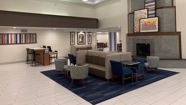 A spacious lobby with a high ceiling, a fireplace, and seating areas. - Holiday Inn Express & Suites Gunnison by IHG (Gunnison)