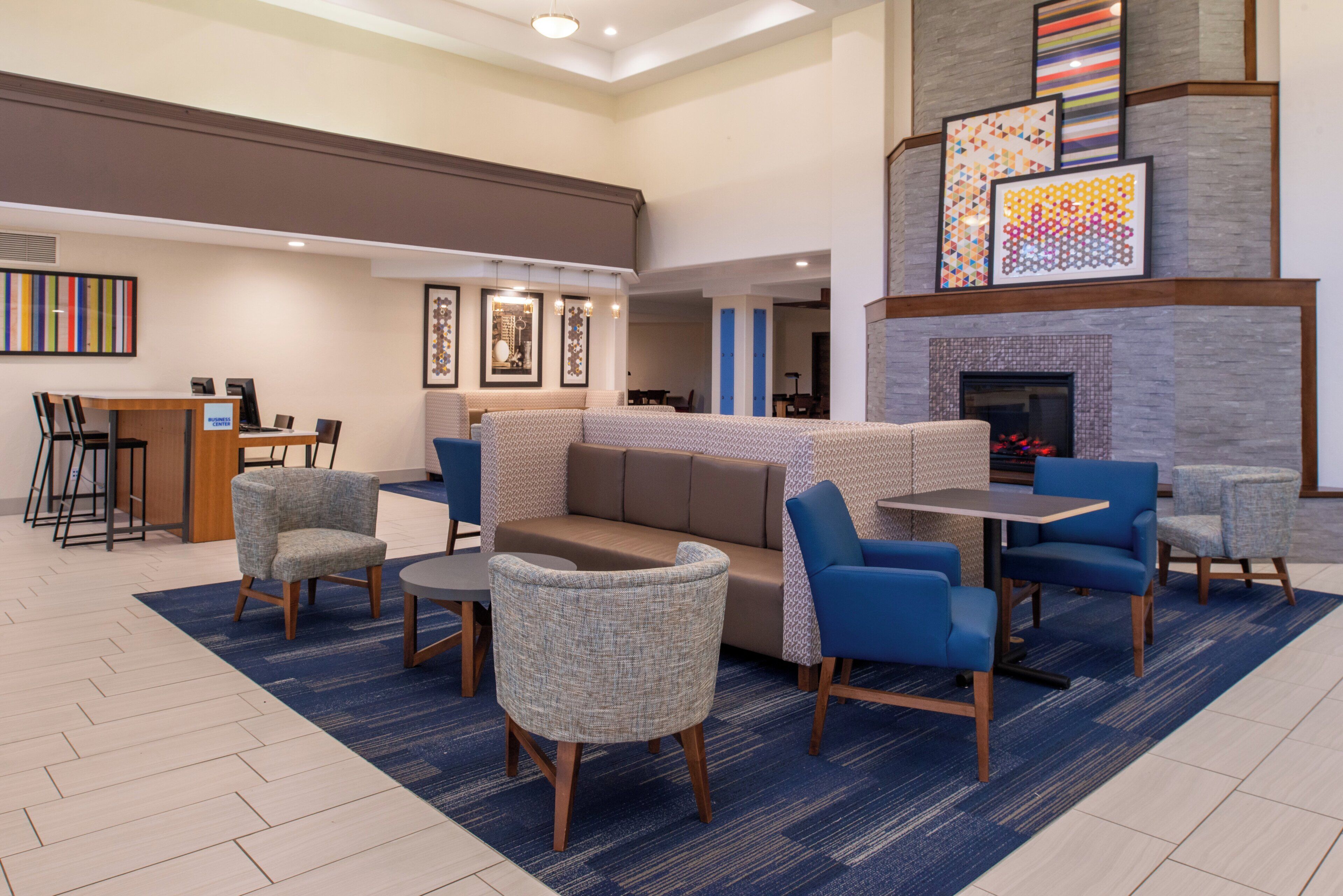 A lobby area with seating arrangements, a reception desk, and a fireplace.