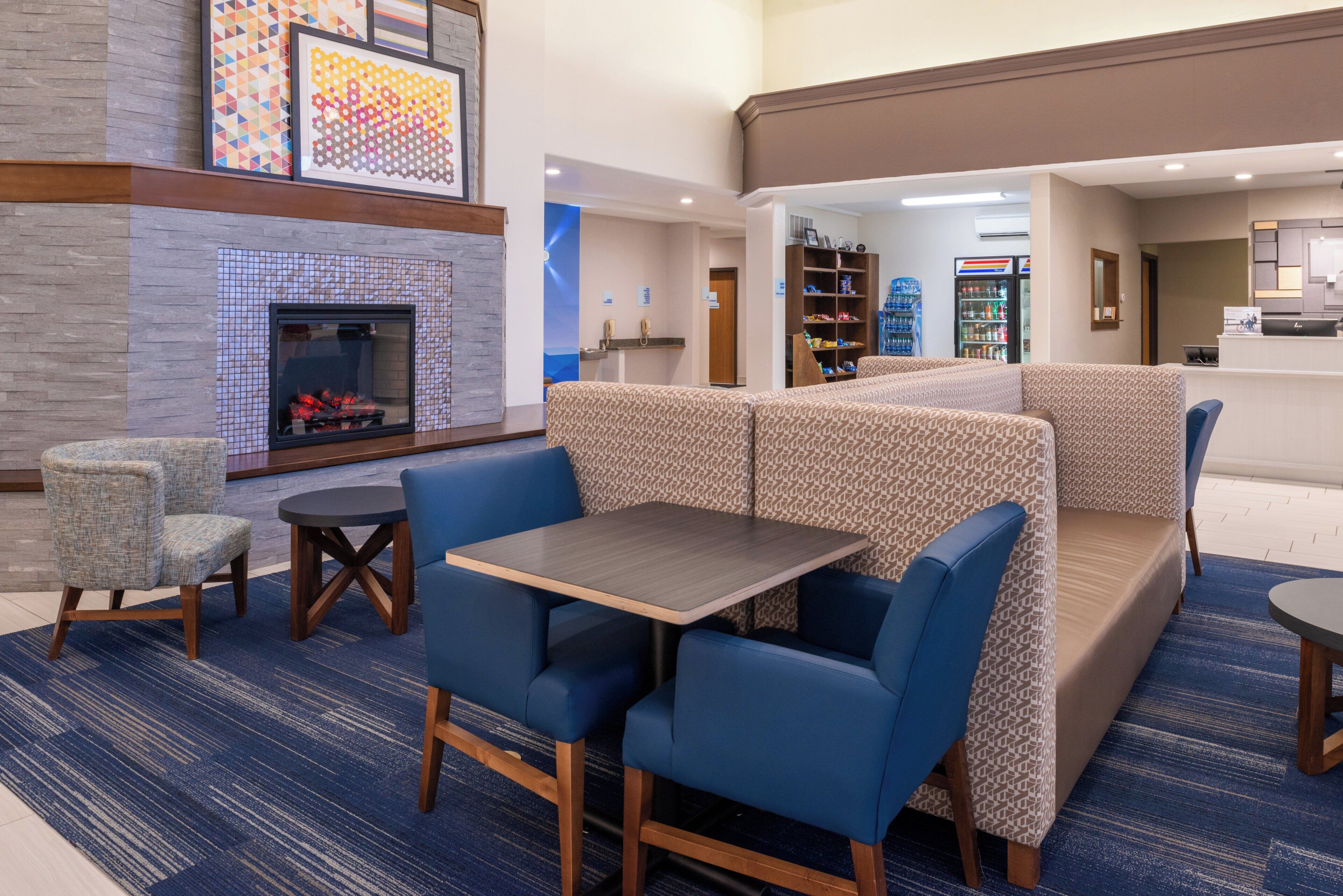 A hotel lobby with a fireplace, seating area, and a reception desk.