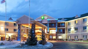 A Holiday Inn Express building with a brick facade, multiple balconies, and a well-lit entrance. - Holiday Inn Express & Suites Gunnison by IHG (Gunnison)