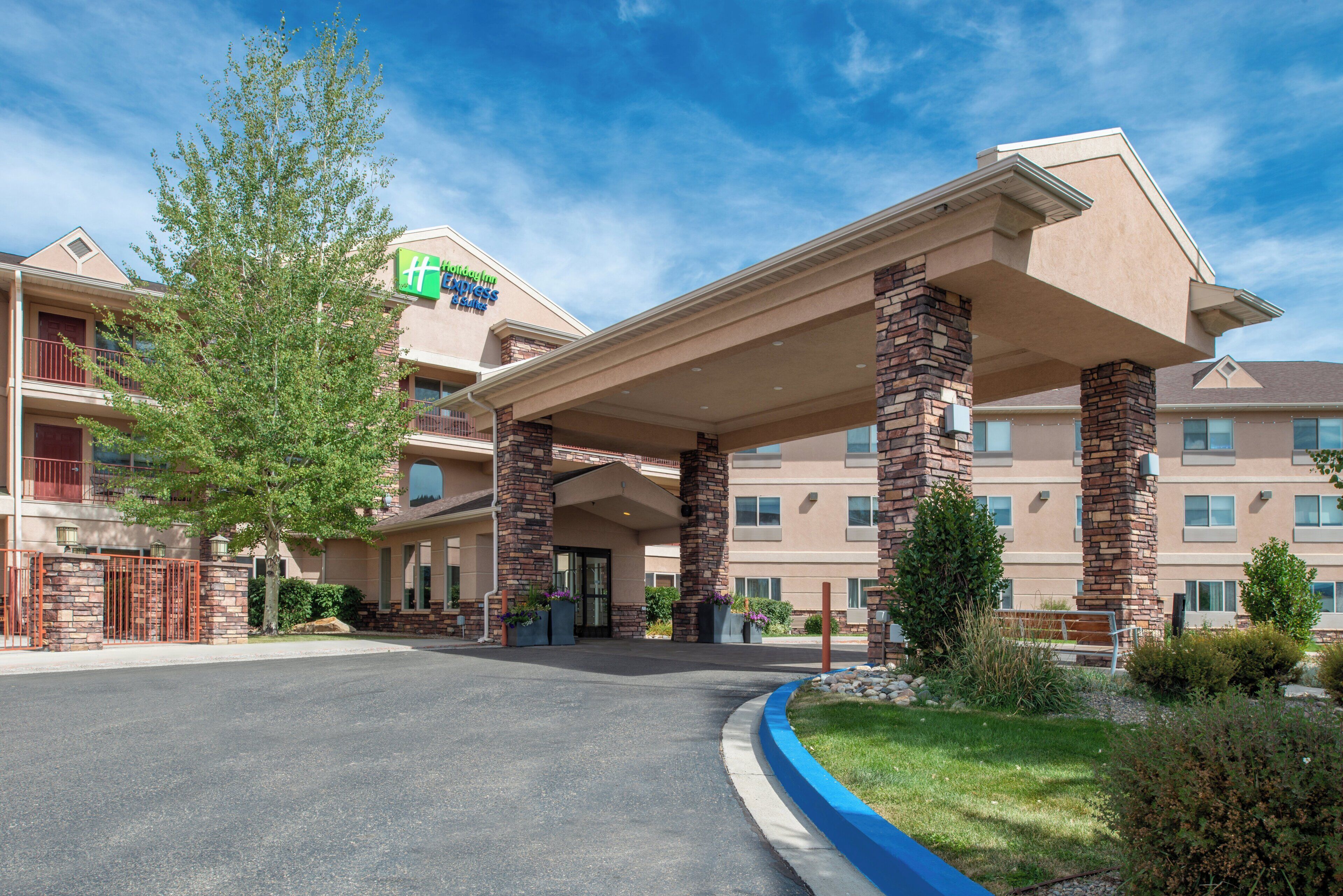 A hotel with a covered entrance, stone pillars, and a sign for Holiday Inn Express.