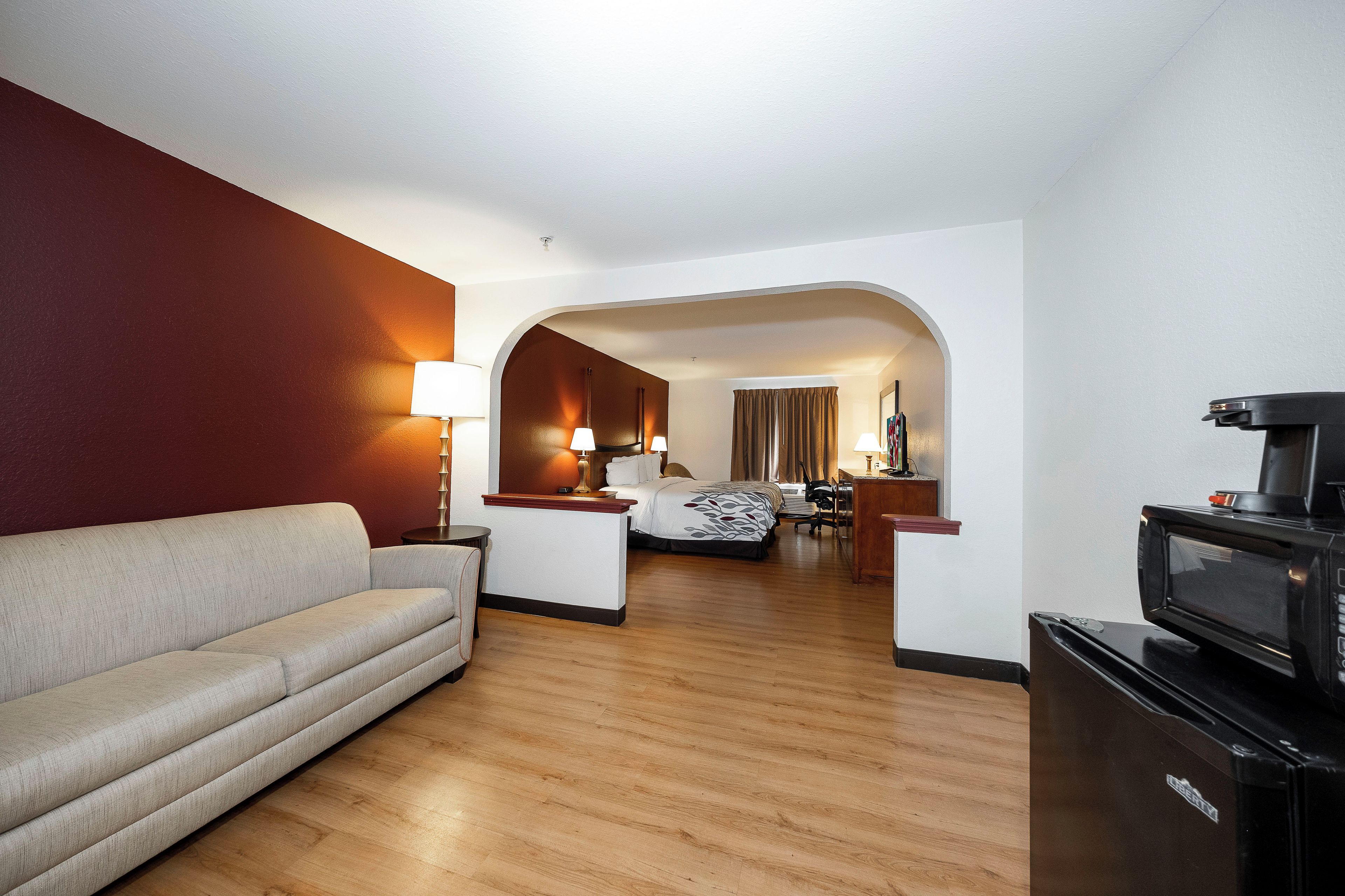 Une chambre d’hôtel avec un canapé, un lit, un bureau et une télévision.