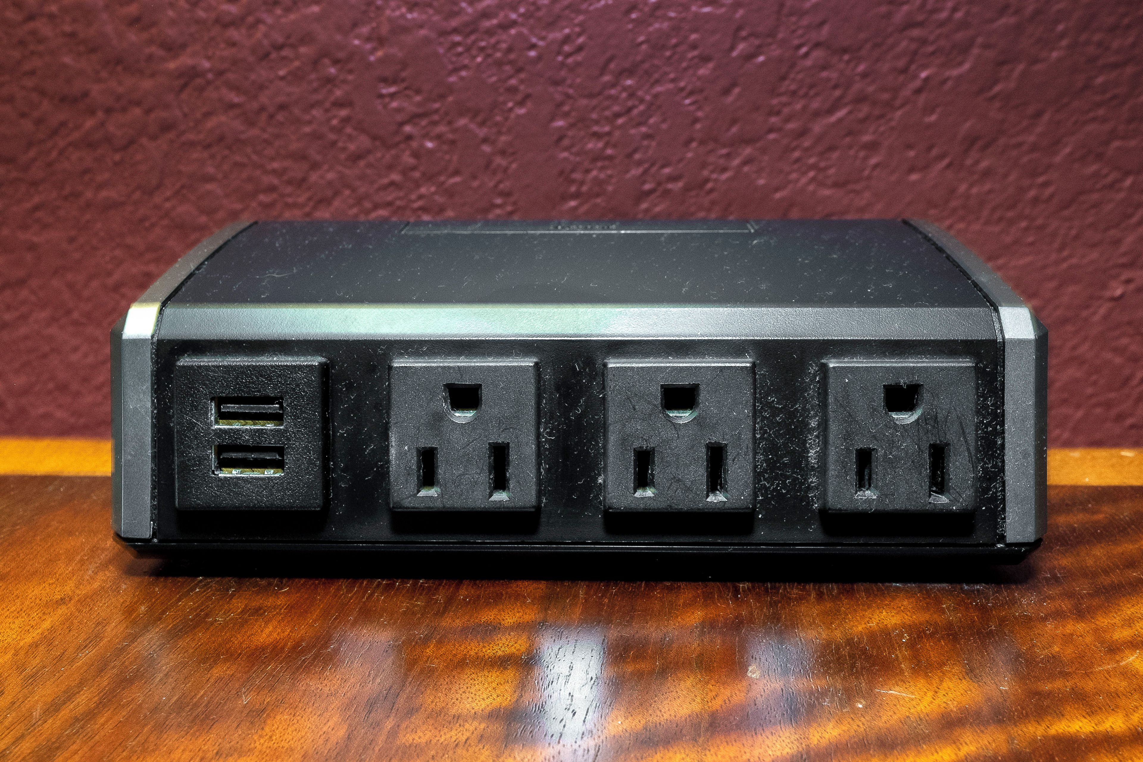 A black power strip with four USB ports and two standard electrical outlets.