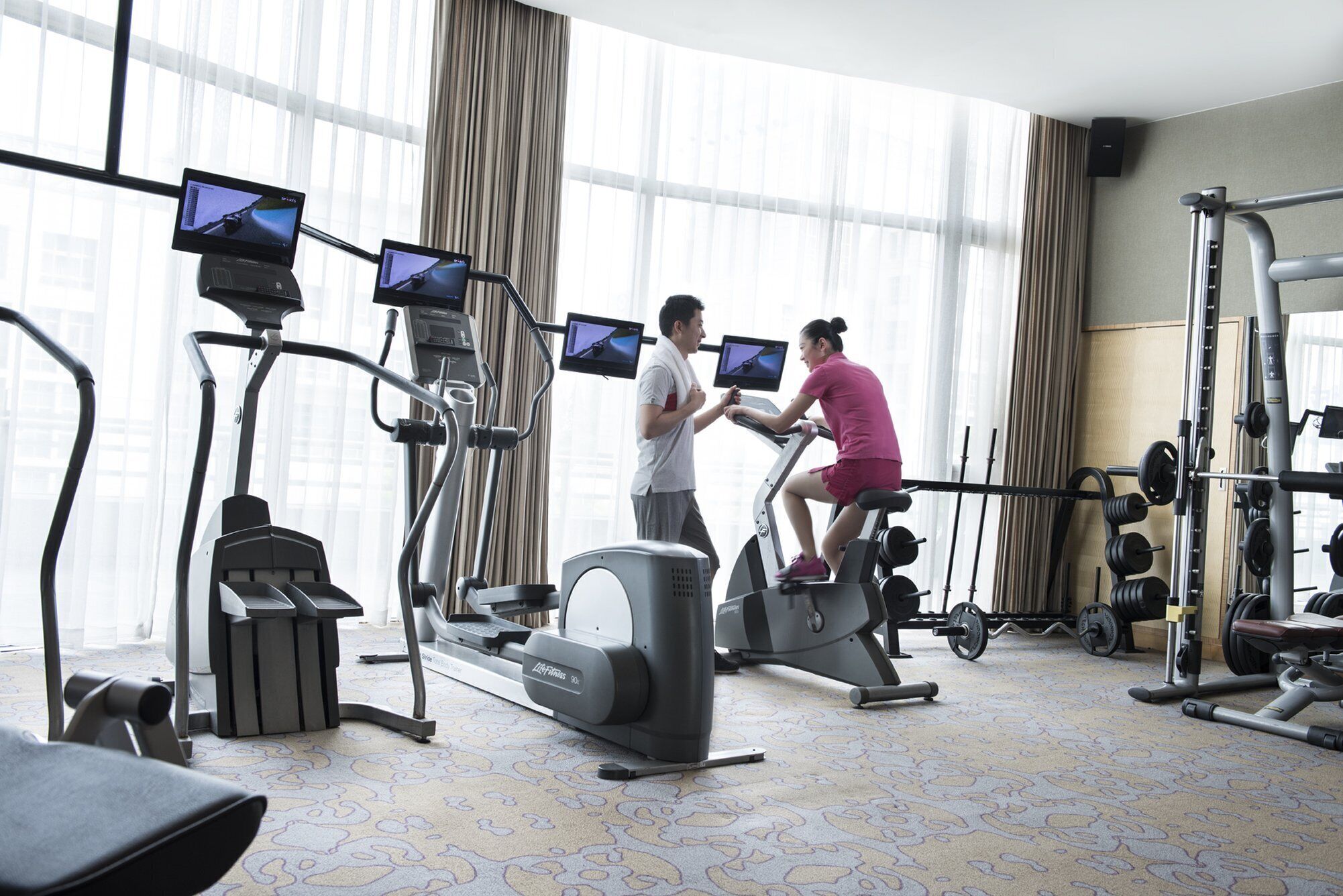 Et fitnesscenter med løbebånd, styrkemaskiner og træningsmonitorer.