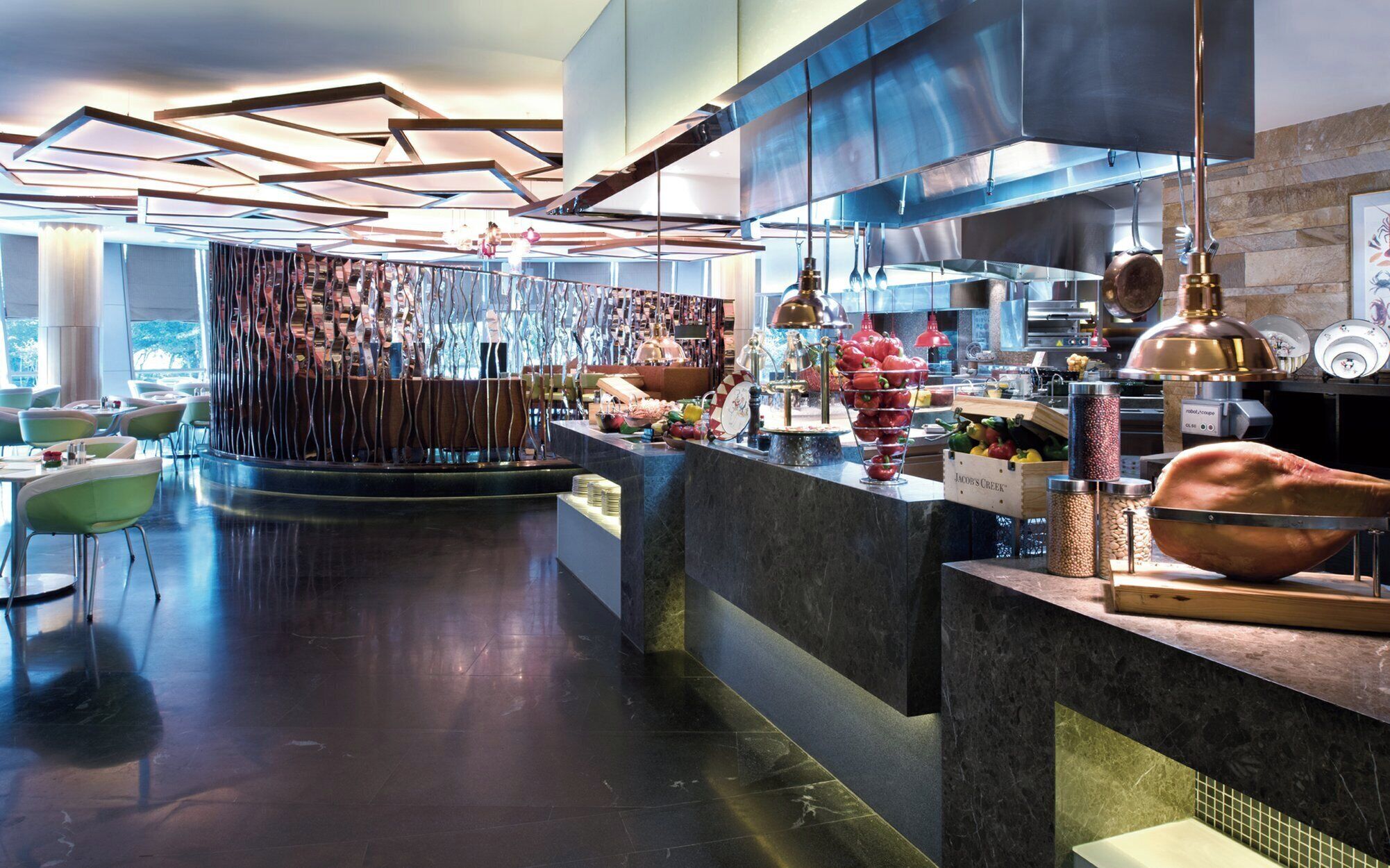 A modern restaurant interior with a central bar area, seating around the bar, and a variety of food and drink displays.