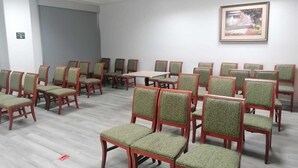 A conference room with rows of green upholstered chairs, a central table, and a framed picture on the wall. - Sierra Huasteca Inn (Ciudad Valles)