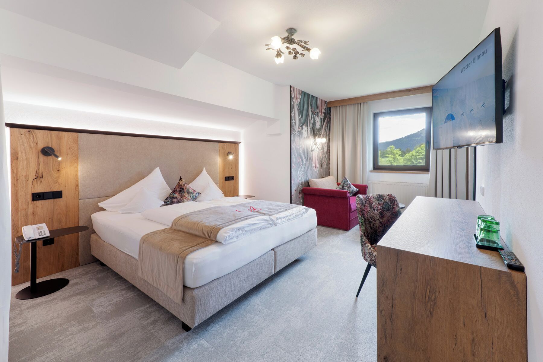 Habitación de hotel con cama, escritorio, silla, televisor y ventana con vistas.