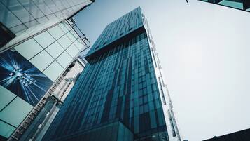 A modern high-rise building with reflective glass windows and a prominent vertical structure.