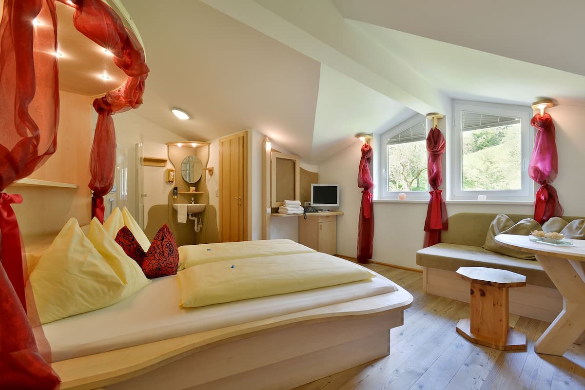 Ein Schlafzimmer mit einem Bett, einem Holztisch, einem Fenster und einem Badezimmer.