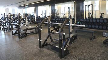 A gym with various exercise equipment, including weight machines and dumbbells.