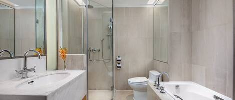 A modern bathroom with a glass-enclosed shower, a double sink vanity, and a standalone bathtub.