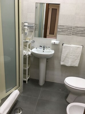 Een douche, een haardroger, pantoffels, een bidet