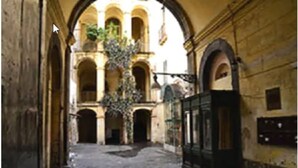 An interior courtyard with arches, a cobblestone floor, and a hanging plant. - Soggiorno Paradiso due (Naples)