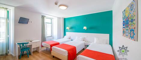 Habitación de hotel con dos camas, un escritorio, una silla, un televisor y una ventana con cortinas.