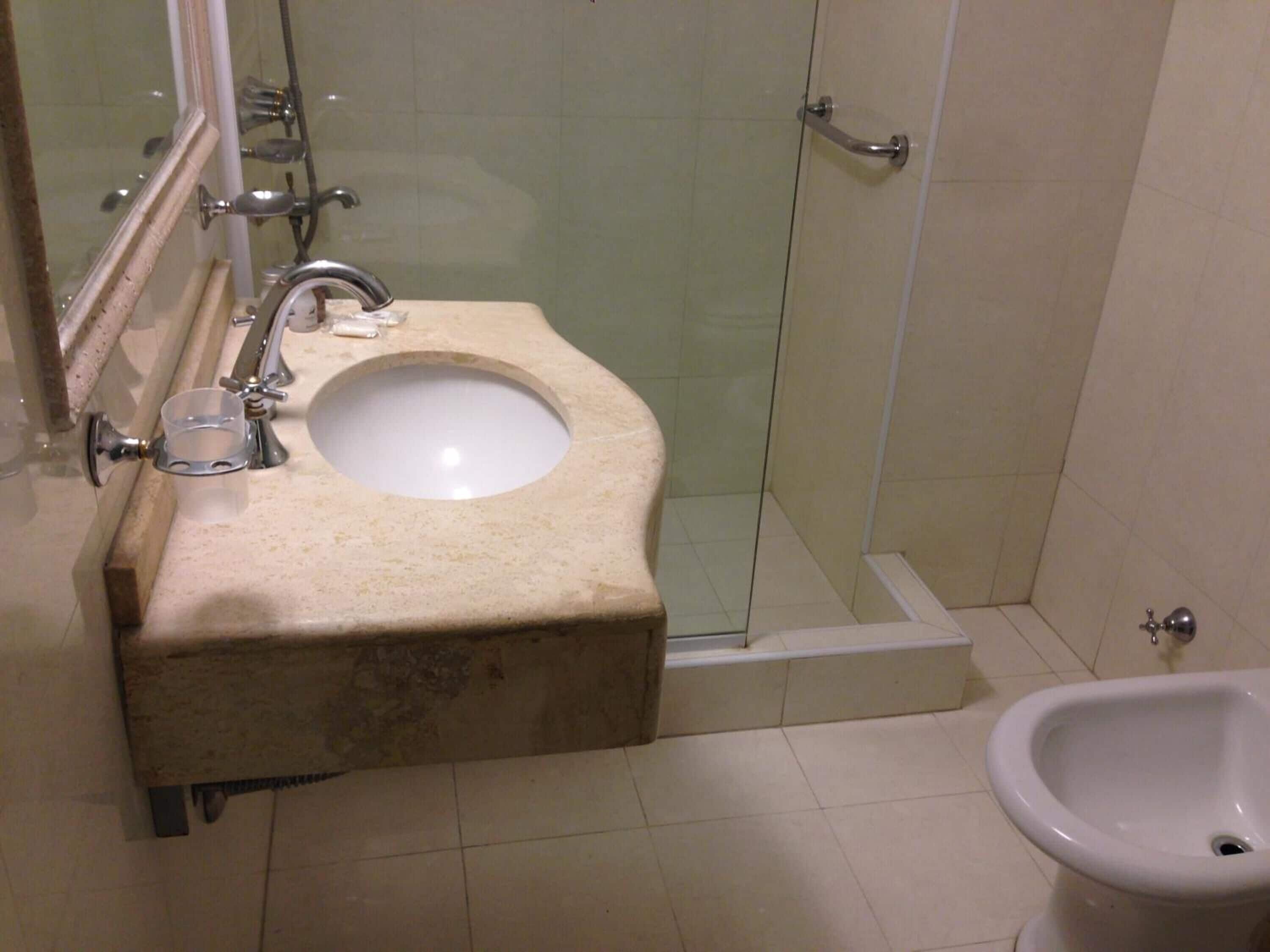 Ein Badezimmer mit Waschbecken, Duschkabine aus Glas und einem Bidet.