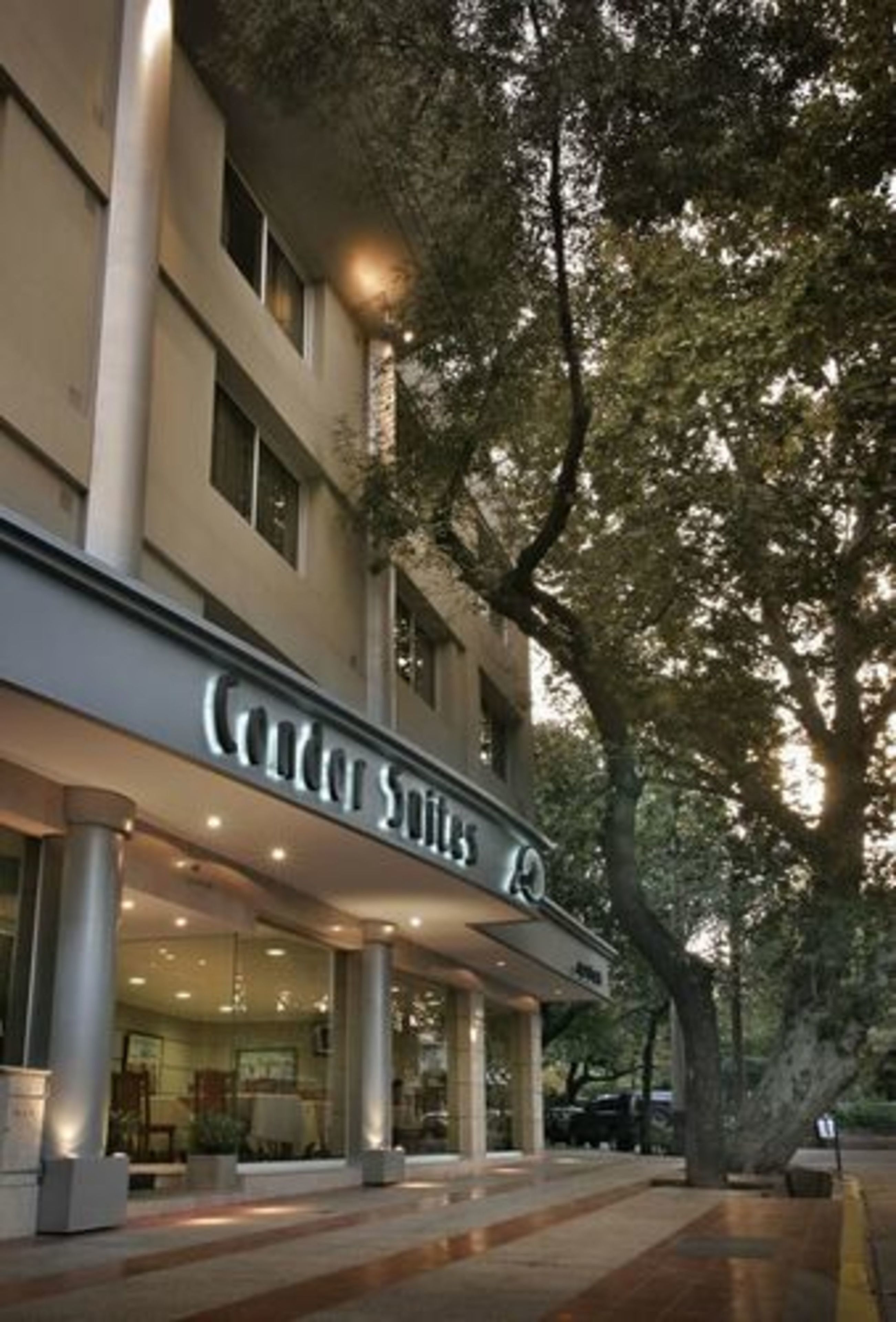 Entrada de hotel com uma placa indicando "Cedar Suites".