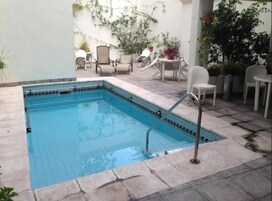 Una piscina al aire libre, tumbonas