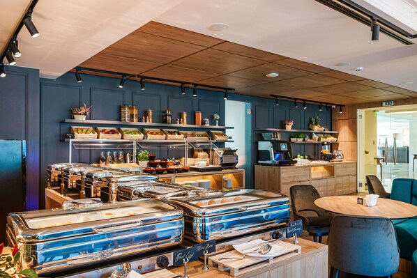 A buffet area with multiple food stations, a coffee machine, and seating arrangements. - Radisson Hotel Plovdiv (Plovdiv)