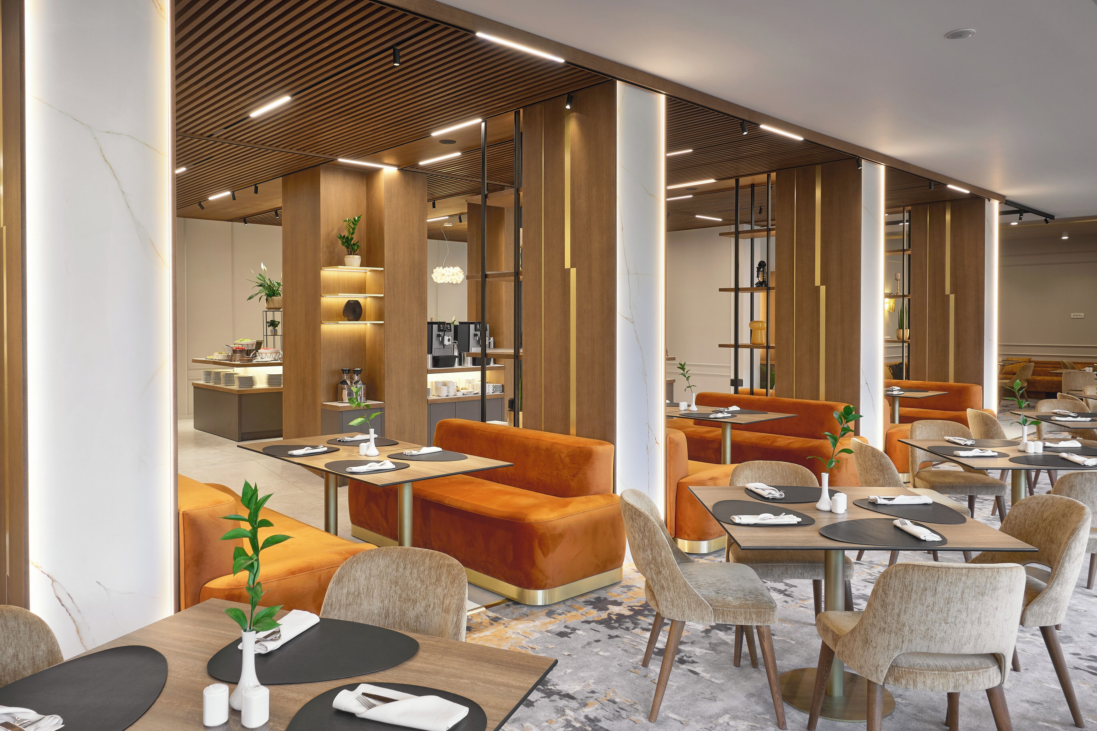 Un restaurante moderno con detalles de madera, asientos anaranjados y un interior limpio y bien iluminado.