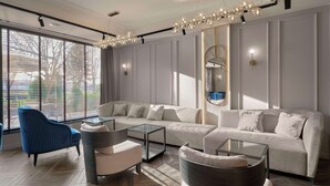 Un salon moderne avec un canapé, des fauteuils et une table basse en verre.