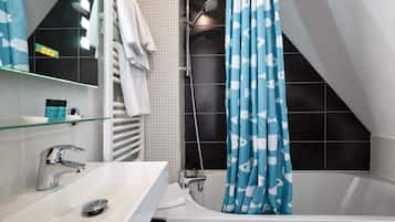 Un baño moderno con un lavamanos blanco, un estante de vidrio, una ducha con cortina azul y paredes cubiertas de baldosas negras.