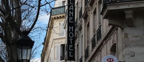 Un edificio con un cartel del Hotel Alane y un cartel del banco HSBC.