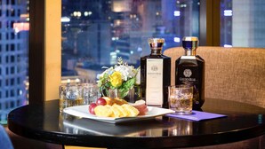 A table with two bottles of Golden Blue, a plate of fruit, and glasses of whiskey. - ibis Ambassador Seoul Myeongdong (Seoul)