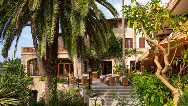 A courtyard with outdoor seating, stone steps, and lush greenery. - Es Moli Hotel (Deià)