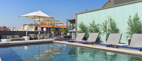 Alberca al aire libre y camastros