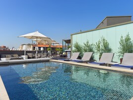 Una piscina al aire libre, tumbonas