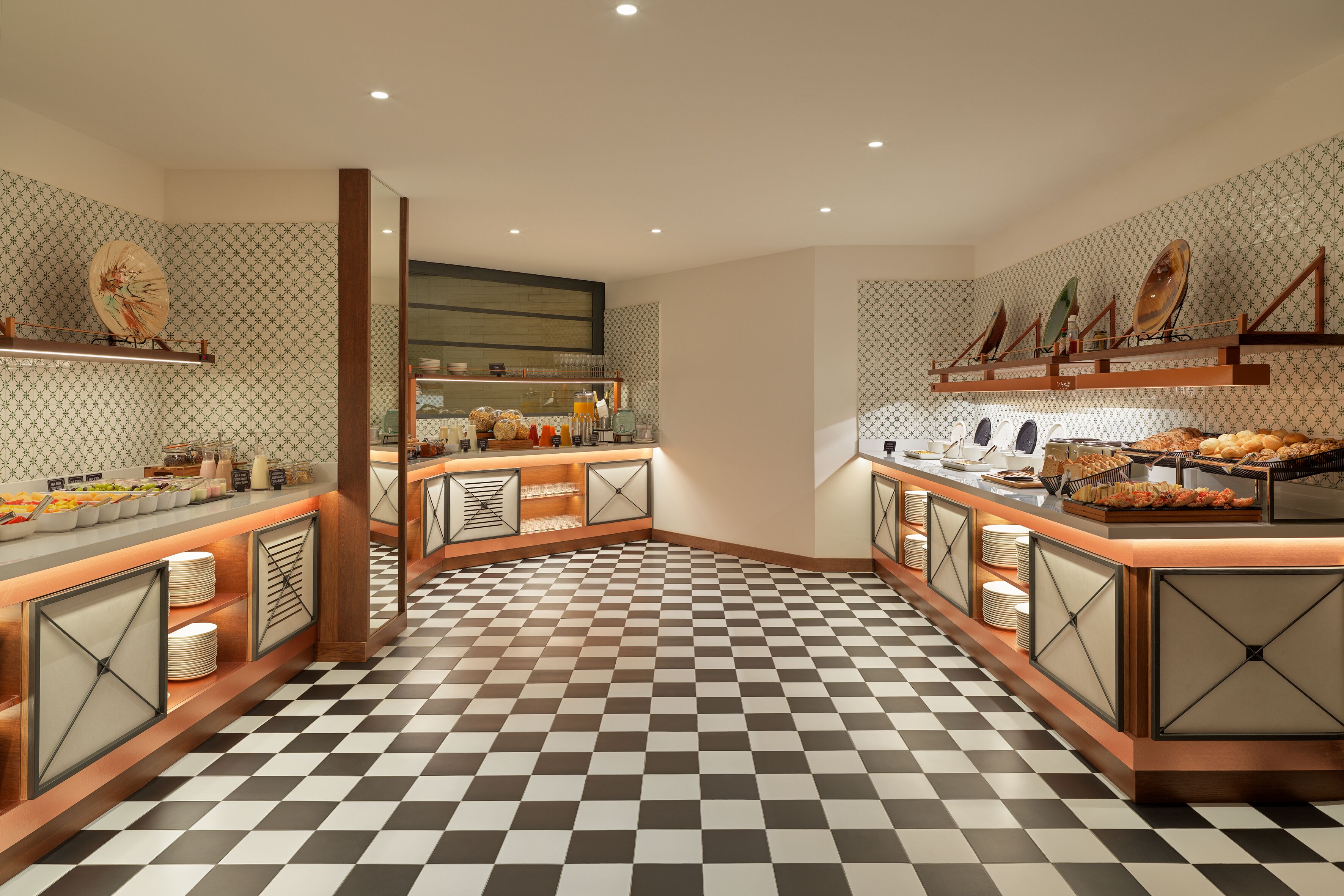 A buffet area with checkered flooring, multiple serving stations, and decorative wall elements.