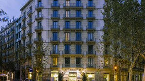 Un hôtel à plusieurs étages, de style architectural européen classique, doté de balcons et de grandes fenêtres.