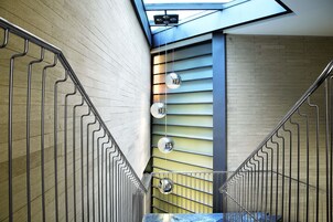A modern staircase with metal railings and a skylight above.
