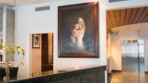 A reception area with a marble counter, a framed portrait on the wall, and a potted plant.
