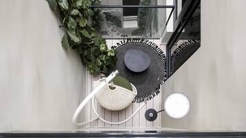 Un interior moderno con piso de vidrio, una planta colgante y un espacio de asientos circular.
