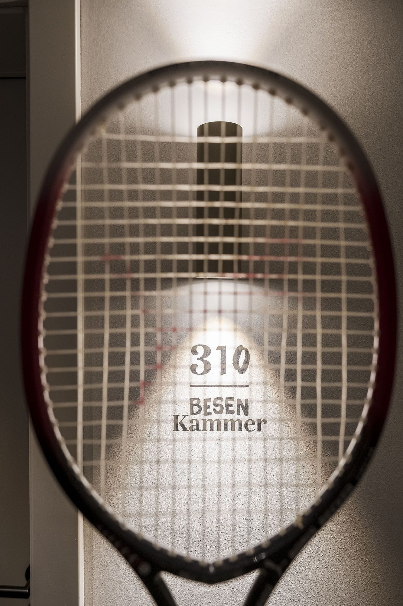 A tennis racket with the number 310 and the text "BESEN KAMMER" on it.