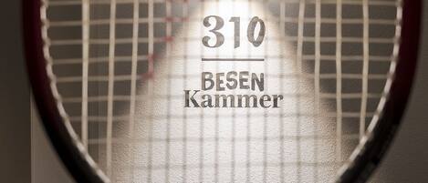 A tennis racket with the number 310 and the text "BESEN KAMMER" on it.