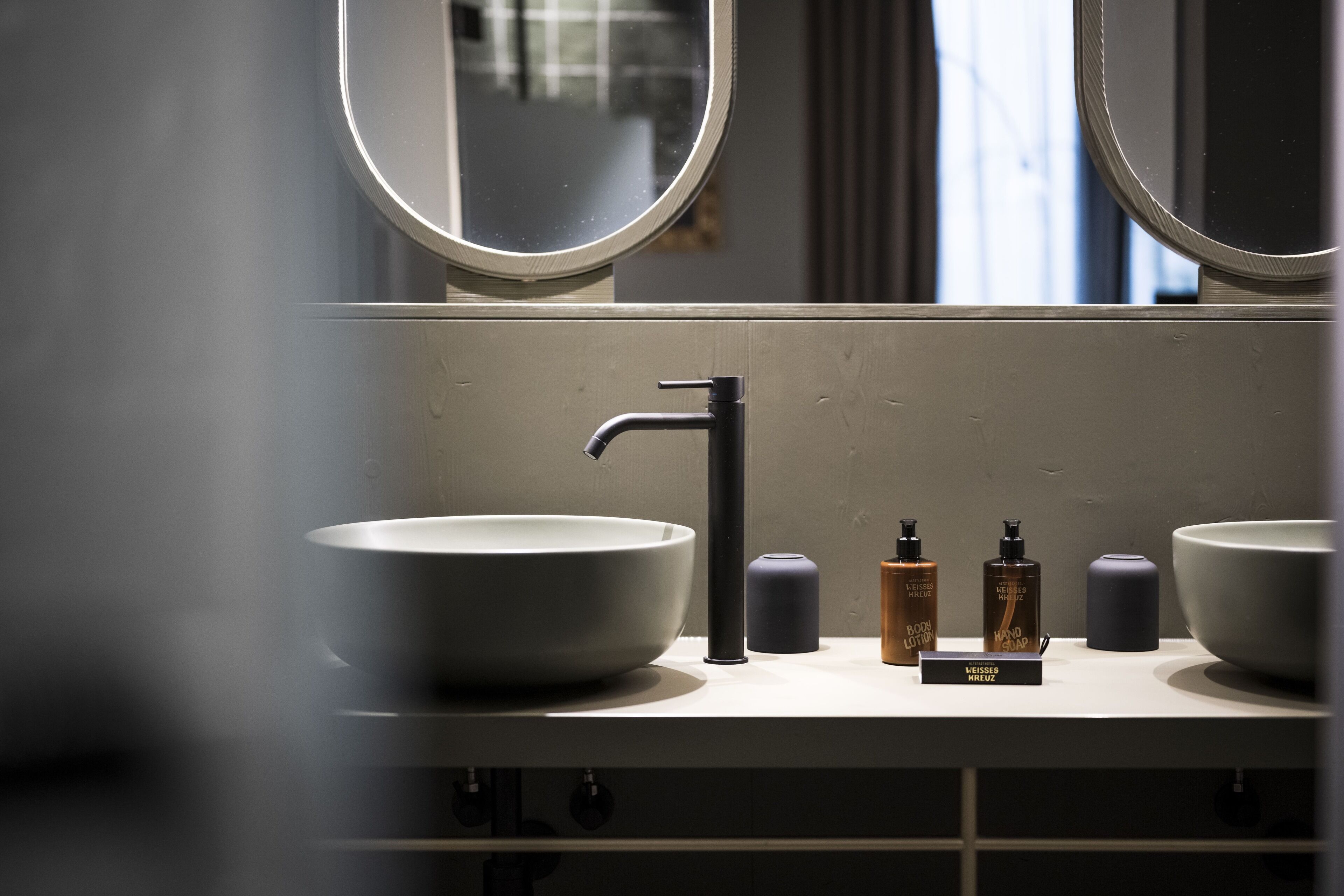 Un bagno con due lavabi, uno specchio e diversi articoli da toilette.